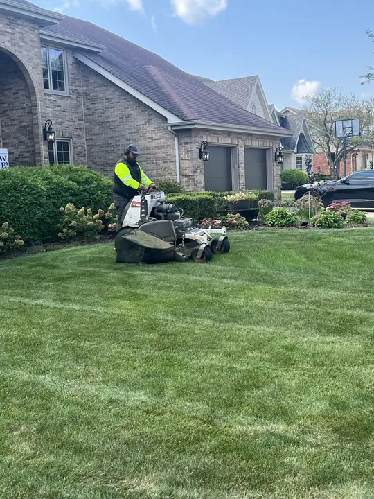 Crew Mowing Front Lawn Stone Home Chicagoland