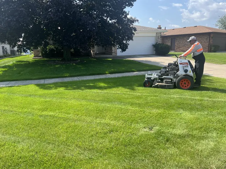 Crew On Stand On Mower Residential Front Lawn Chicagoland