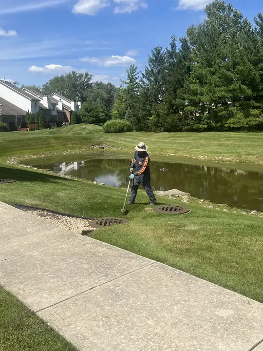 Crew Trimming Retention Pond Bank Chicagoland
