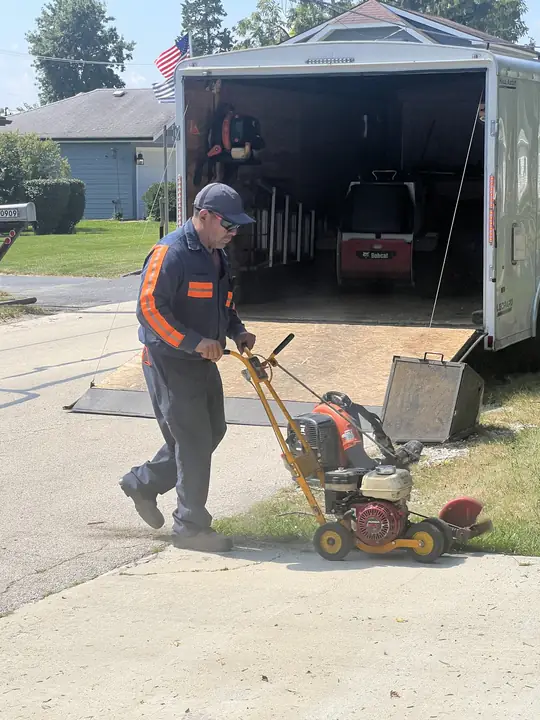 Crew Unloading Lawn Aerator From Trailer Chicagoland